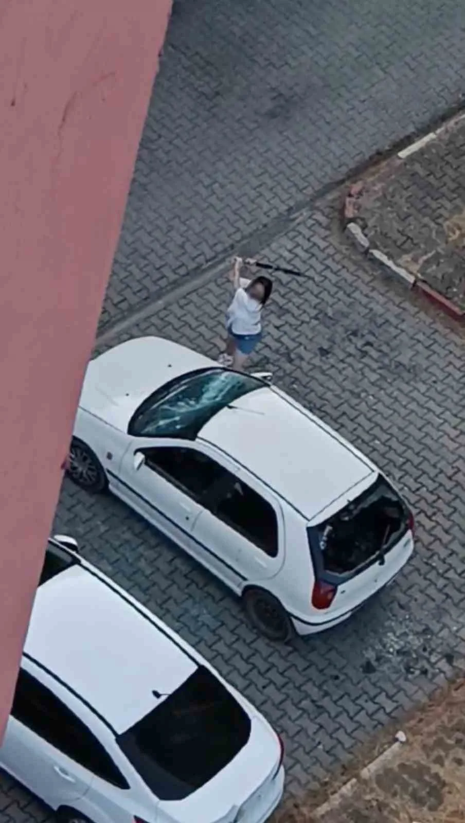 Park halindeki otomobilin camlarını kıran kadın kamerada