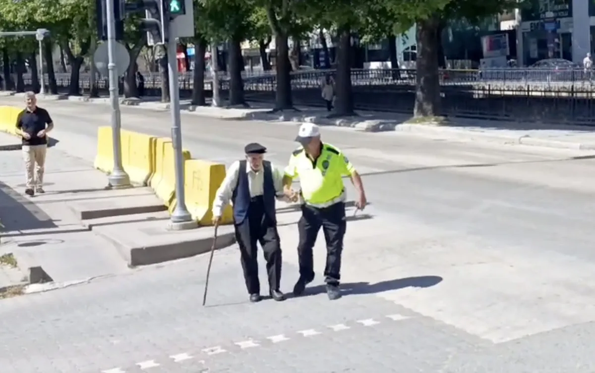 Trafik polisinin yürümekte zorlanan yaşlı adama yardımı yürekleri ısıttı